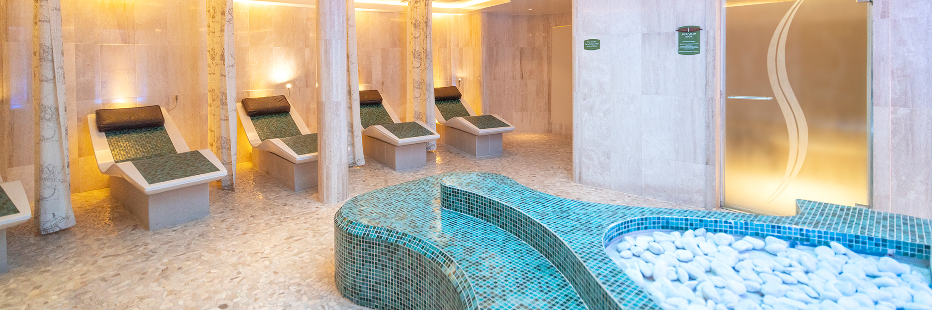 Spa relaxation room with heated loungers and soft lighting on the Disney Wonder cruise ship.
