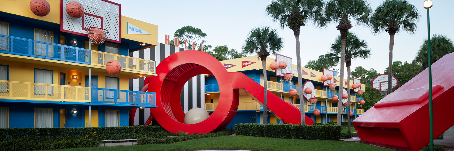 Basketball-themed hotel courtyard with basketball hoops, basketballs, and a large red whistle statues.