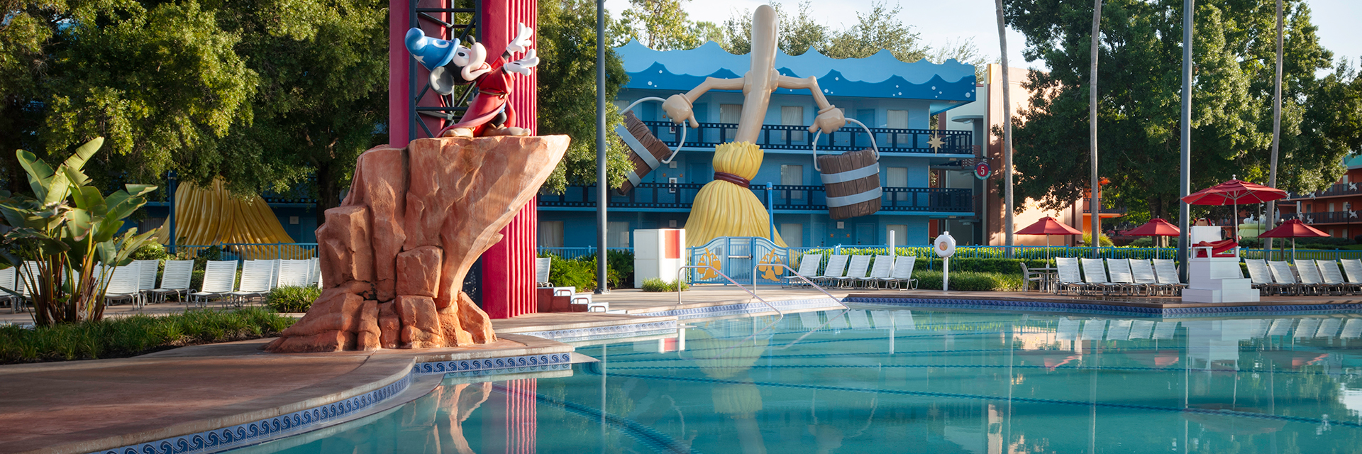 Fantasia-themed pool with Sorcerer Mickey statue and palm trees at Disney’s All-Star Movies Resort.